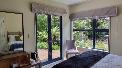 a bedroom with a large window with a bed and a mirror at Christchurch Airport House in Christchurch