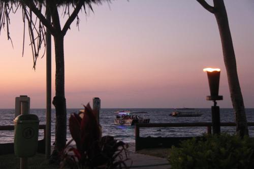 a sunset over the ocean with boats in the water at Nirvana in Tangalooma