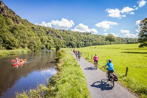 a group of people riding bikes on a path next to a river at GITE DE LA BUTTE le charme de la Normandie entre Terre et Mer in Condé-sur-Vire