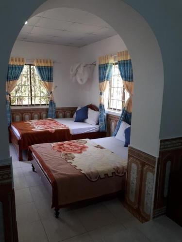 a bedroom with two beds and an archway at Duong Sat Hotel in Khu Chi Lăng