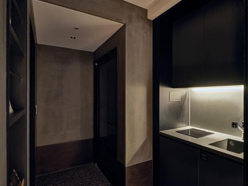 a kitchen with black cabinets and a sink at Sono Pet Clubs & Resorts Vivaldi Park in Hongcheon