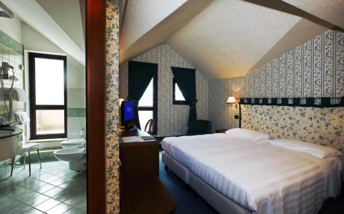 a bedroom with a large bed and a bathroom at Rizzi Aquacharme Hotel & Spa in Boario Terme
