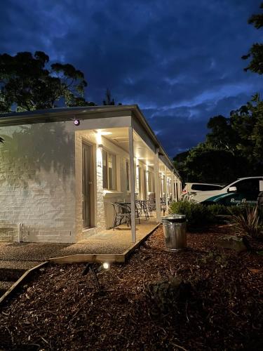 a small house with a porch at night at Balan Village Motel in Nowra