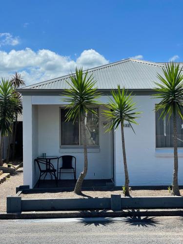 a white house with palm trees in front of it at Balan Village Motel in Nowra