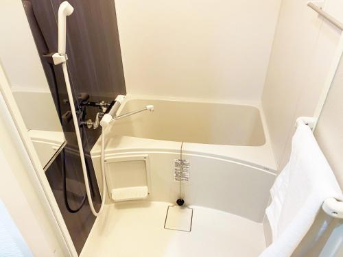 a small bathroom with a tub and a toilet at @RLiS_house大阪ドームシティ in Osaka