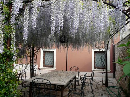 a table and chairs in a courtyard with wisteria at Residence Villa Vinco in Tregnago