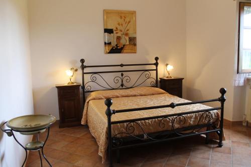 ピティリアーノにあるAgriturismo Pietramoraのベッドルーム1室(ベッド1台、テーブル、ランプ2つ付)