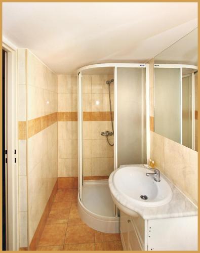 a bathroom with a sink and a shower at Hotel & Restauracja Glass in Radom