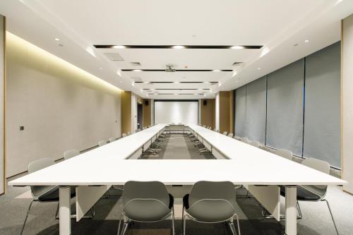 a long conference room with a white table and chairs at Holiday Inn Express Harbin Qunli by IHG in Harbin