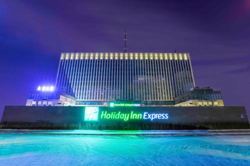 duży budynek z znakiem przed nim w obiekcie Holiday Inn Express Harbin Qunli, an IHG Hotel w mieście Harbin