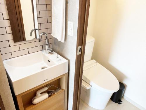 a small bathroom with a sink and a toilet at @RLiS_house大阪ドームシティ in Osaka