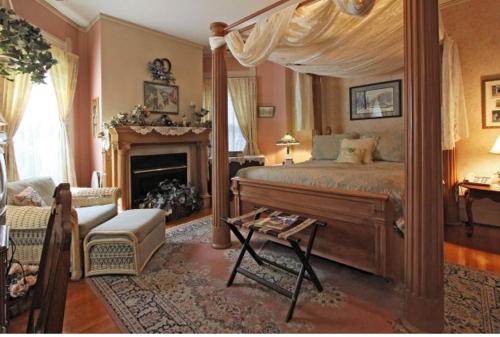 a bedroom with a canopy bed and a fireplace at Old Northside Bed & Breakfast in Indianapolis