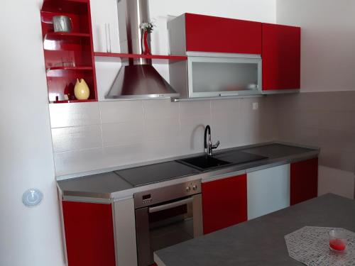 a kitchen with red and white cabinets and a sink at H&T in Senj