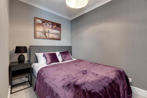 een slaapkamer met een bed met een paars dekbed bij Avanport Studio Gdynia in Gdynia
