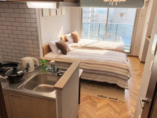 a small room with a bed in a box next to a sink at @RLiS_house大阪ドームシティ in Osaka