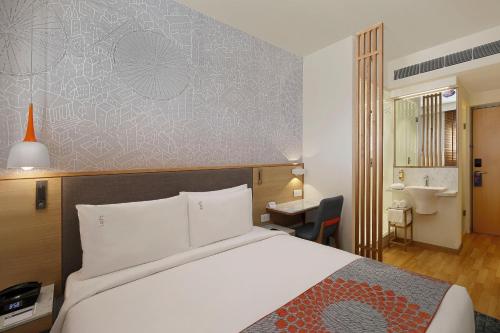 ein Hotelzimmer mit einem Bett und einem Bad in der Unterkunft Holiday Inn Express Bengaluru Yeshwantpur, an IHG Hotel in Bangalore