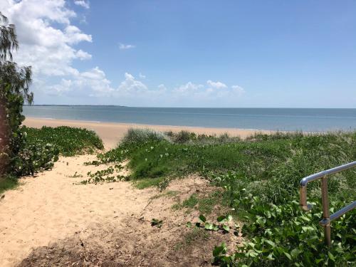 a sandy beach with the ocean in the background at Hervey Bay Motel in Hervey Bay