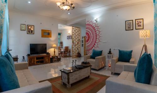 a living room with two couches and a tv at La Maison - A Boutique Bed and Breakfast in Bīr