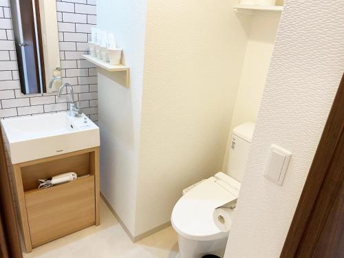 a small bathroom with a toilet and a sink at @RLiS_house大阪ドームシティ in Osaka