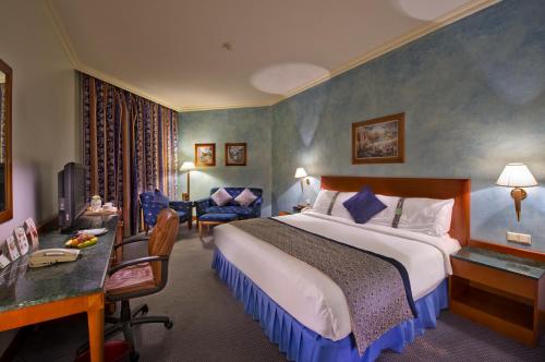a hotel room with a large bed and a desk at Holiday Inn Al Khobar by IHG in Al Khobar