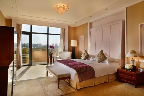 a bedroom with a large bed and a large window at Crowne Plaza Ordos, an IHG Hotel in Ordos