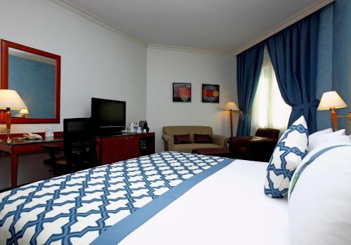 a hotel room with a large bed in a room at Holiday Inn Al Khobar by IHG in Al Khobar