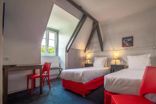 Habitación con 2 camas con sillas rojas y escritorio. en Auberge De Kerveoc'h, en Douarnenez