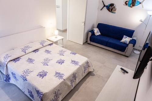 a bedroom with a bed and a blue couch at Marina in Brolo