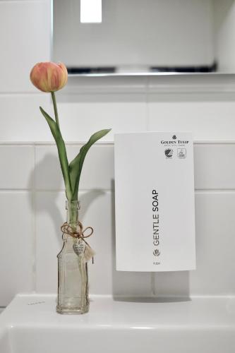 a flower in a glass vase on a counter at Tulip Inn Frankfurt Airport in Neu Isenburg