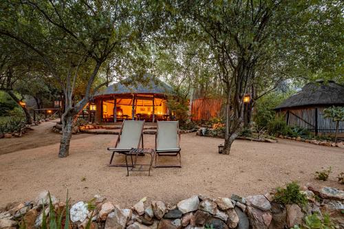 two chairs sitting in a yard with a building at Umlani Bushcamp in Timbavati Game Reserve