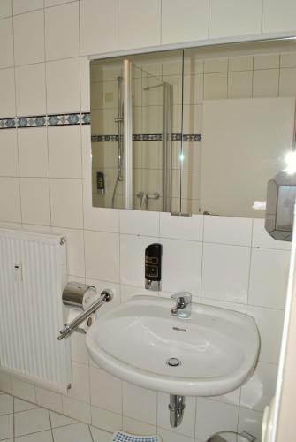 a white bathroom with a sink and a mirror at Gasthof Kampenwand Aschau in Aschau im Chiemgau