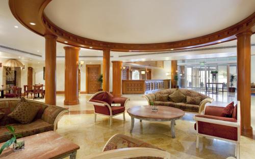 a lobby with couches and a table and chairs at Holiday Inn Al Khobar by IHG in Al Khobar