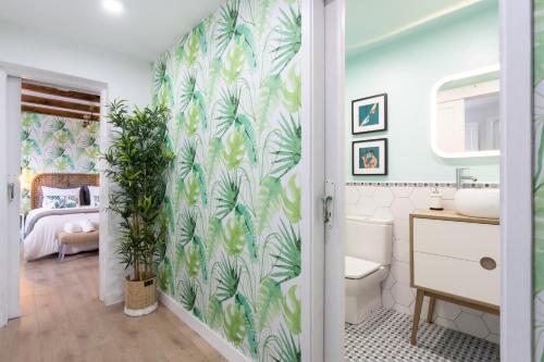 a bathroom with a green leafy wallpaper at Home2Book Vintage American Deluxe La Laguna in Las Lagunas