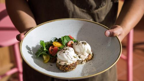a person holding a bowl of food with ice cream at Hotel Indigo Adelaide Markets by IHG in Adelaide