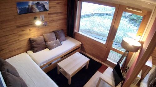 Plagne VillagesにあるPlagne Villagesのソファと窓が備わる小さな客室です。