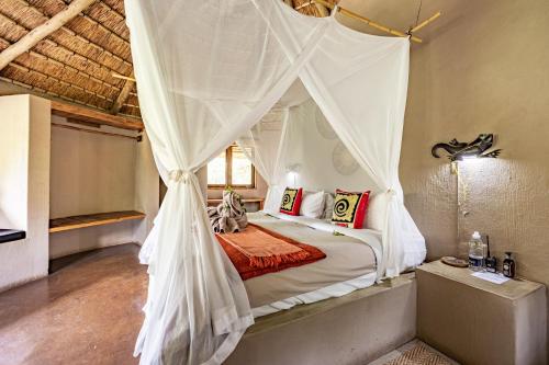 a bedroom with a bed with a mosquito net at Umlani Bushcamp in Timbavati Game Reserve
