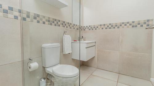 a bathroom with a toilet and a shower at Sea Breeze Guest House in Bloubergstrand