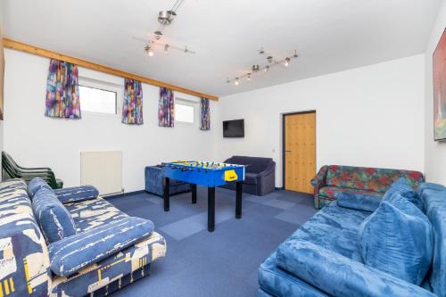 a living room with blue couches and a table at Aparthotel am Reitecksee in Flachau