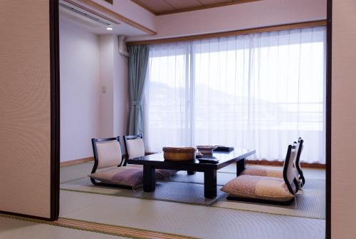 a room with a table and two chairs and a mirror at Hotel Sunmi Club in Atami