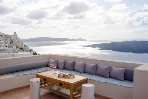a balcony with a table and a view of the ocean at Panorama Suites in Fira