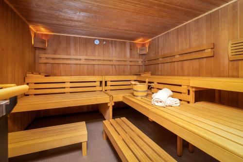 a sauna with wooden benches and towels in it at Aparthotel am Reitecksee in Flachau