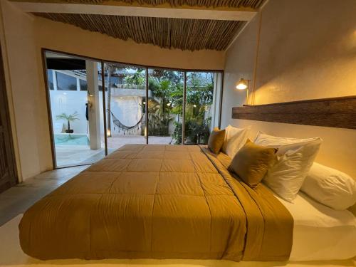 坎古的住宿－AMMA Oasis，卧室配有一张带黄色床单和枕头的大床。
