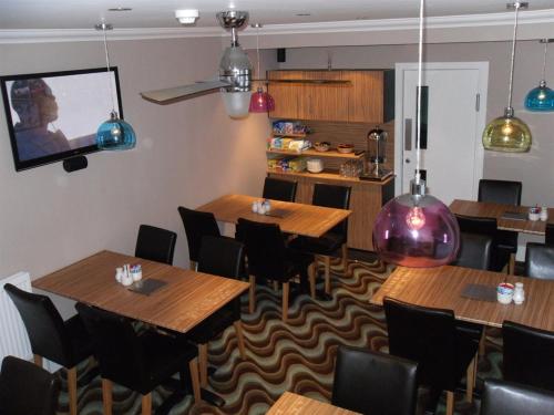 un ristorante con tavoli e sedie in legno e una TV di The Craimar a Blackpool