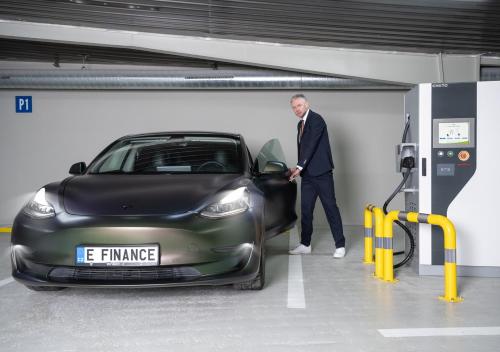 un hombre alimentando un coche en un estacionamiento en EFI SPA Hotel Superior & Pivovar, en Brno