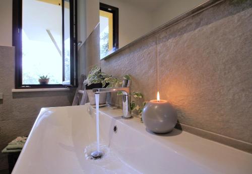 a bathroom sink with a candle on top of it at Il RosAle a Celle Ligure in Celle Ligure