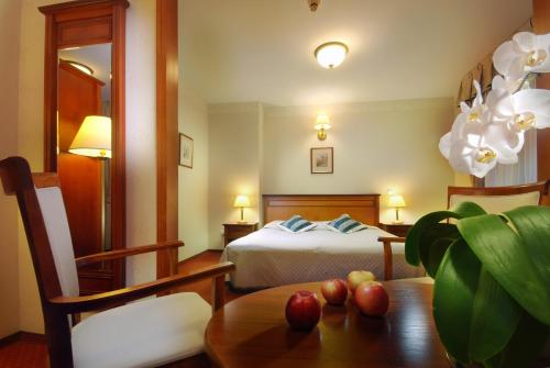Un dormitorio con una cama y una mesa con manzanas. en Hotel Basztowy, en Sandomierz