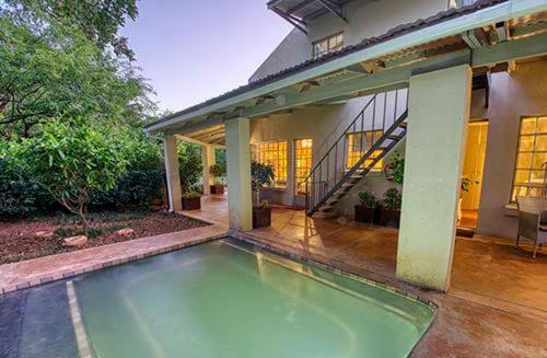a swimming pool in front of a house at Kruger park House in Hazyview