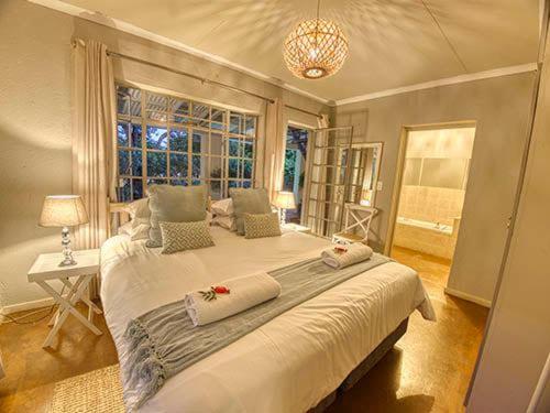 a bedroom with a large bed and a window at Kruger park House in Hazyview