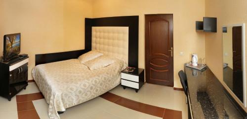 a bedroom with a bed and a dresser and a television at Гранд Алексік in Truskavets