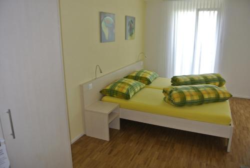 um quarto com uma cama com duas almofadas e uma janela em Hotel Garni Bären Bazenheid em Bazenheid